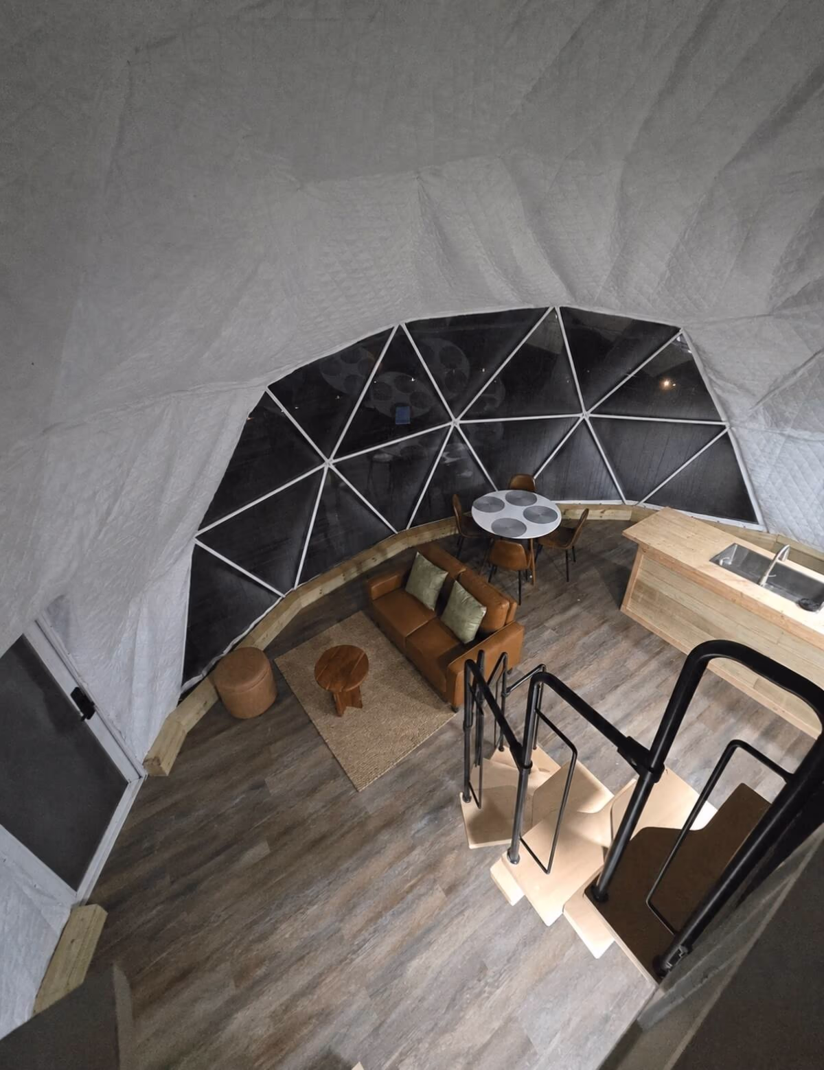 View from the dome loft down to the living area, dining table and kitchen counter