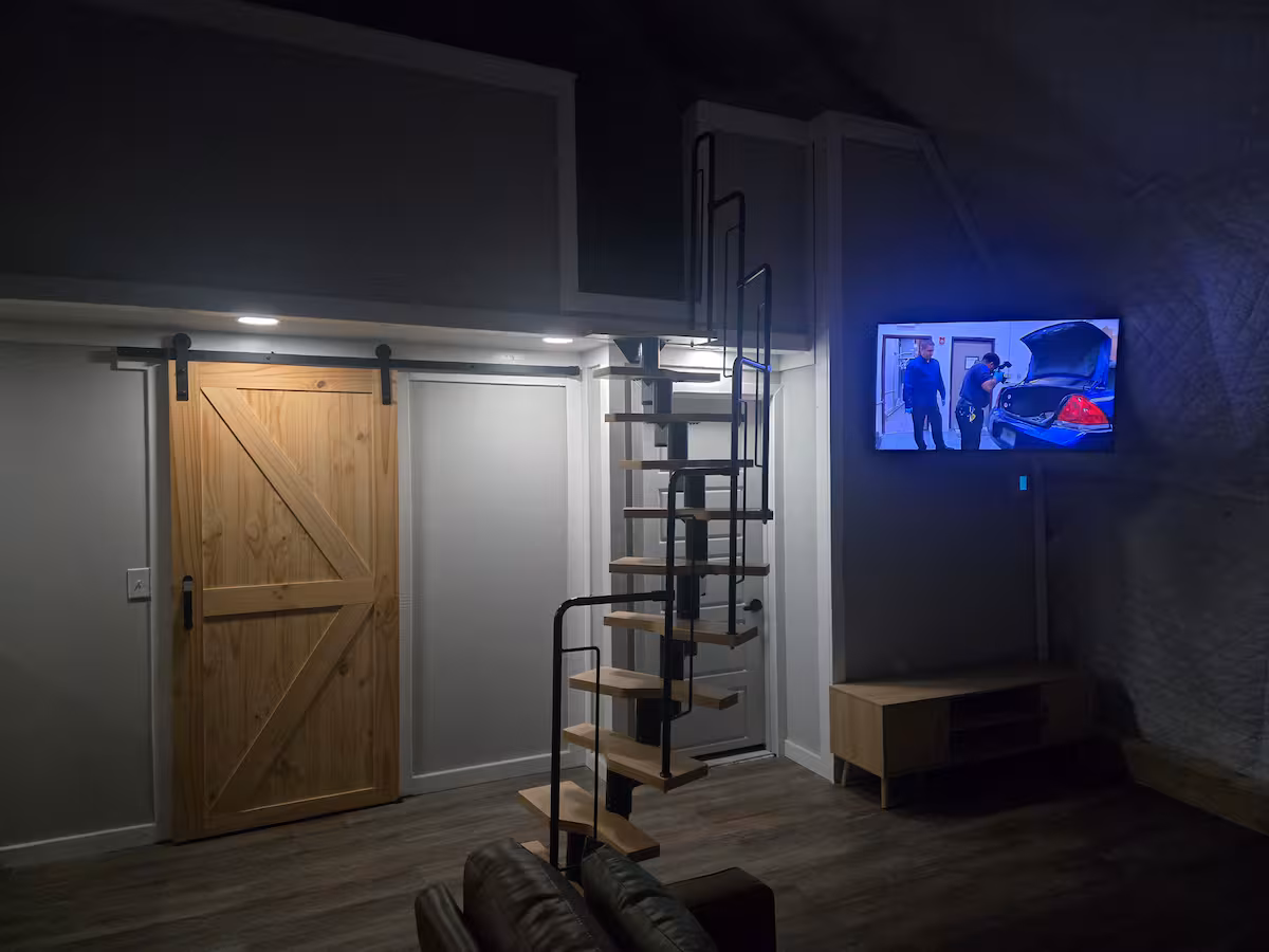 Dome living room at night with wall-mounted smart TV and sliding barn door