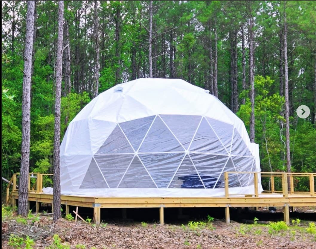 The Glamping Spot geodesic dome exterior at night with ambient lighting