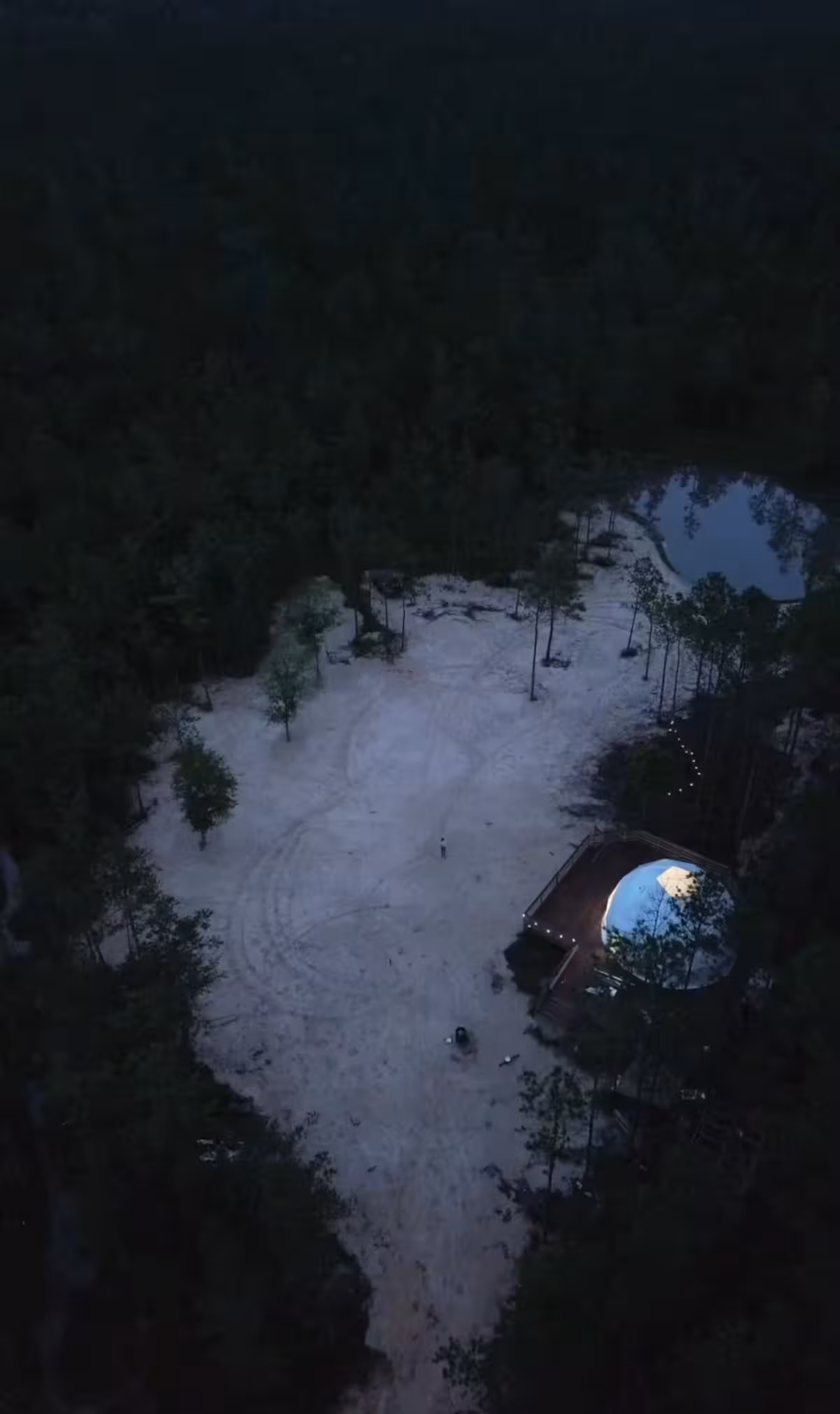 The Glamping Spot geodesic dome exterior at night with ambient lighting