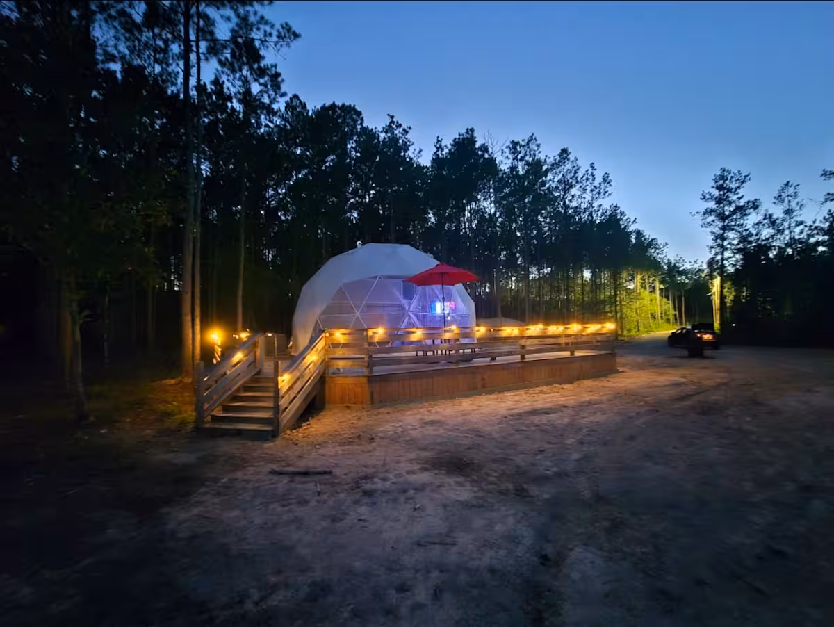 The dome at dusk with string lights strung along the wooden deck, Kountze Texas