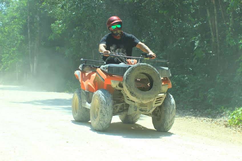 Person riding ATV through jungle trail